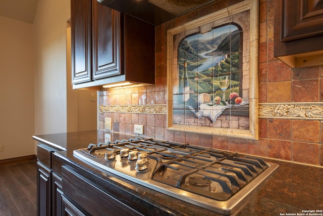 kitchen with dark wood-type flooring, stainless steel gas cooktop, backsplash, and dark brown cabinets