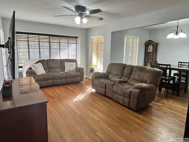 living room featuring wood-type flooring and ceiling fan with notable chandelier