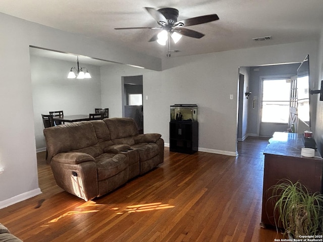 living room with dark hardwood / wood-style floors and ceiling fan with notable chandelier