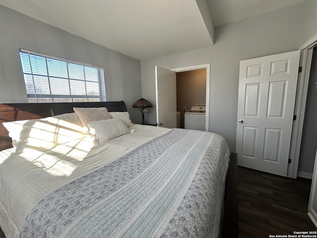 bedroom with dark hardwood / wood-style flooring and washer / dryer