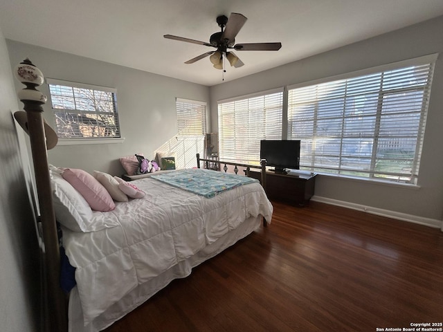 bedroom featuring dark hardwood / wood-style flooring, multiple windows, and ceiling fan