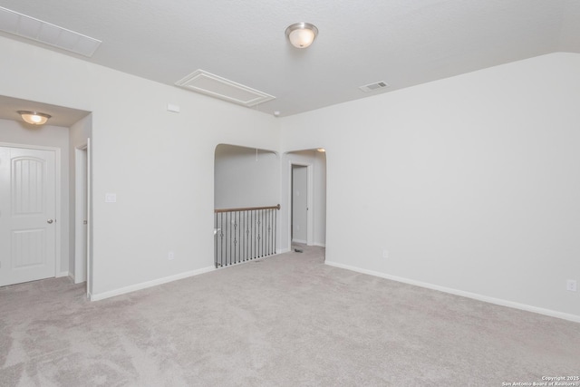 unfurnished room with light colored carpet and vaulted ceiling