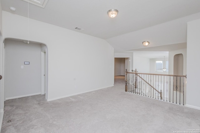 carpeted empty room with vaulted ceiling