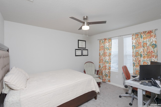 carpeted bedroom featuring ceiling fan and a textured ceiling