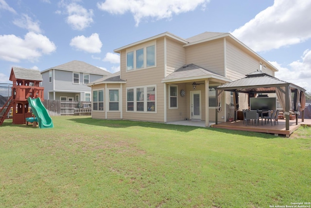 back of house with a gazebo, a playground, a deck, and a lawn