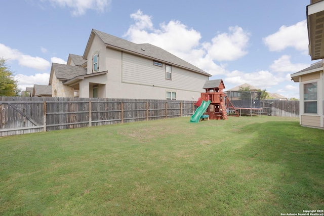 view of yard featuring a playground and a trampoline