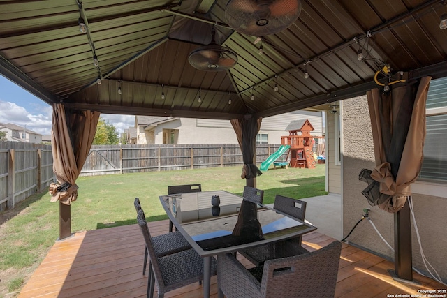 view of patio featuring a wooden deck, a gazebo, and a playground