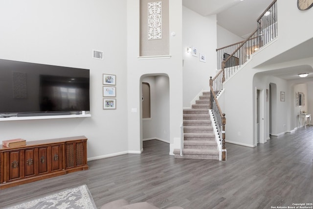 unfurnished living room featuring hardwood / wood-style floors and a high ceiling