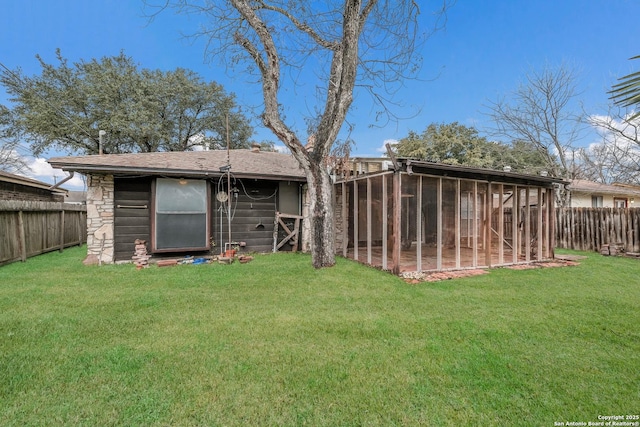 rear view of house featuring an outdoor structure and a yard