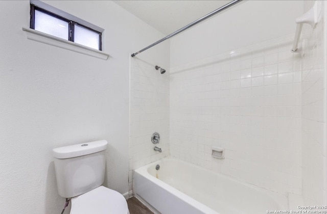 bathroom with tiled shower / bath and toilet