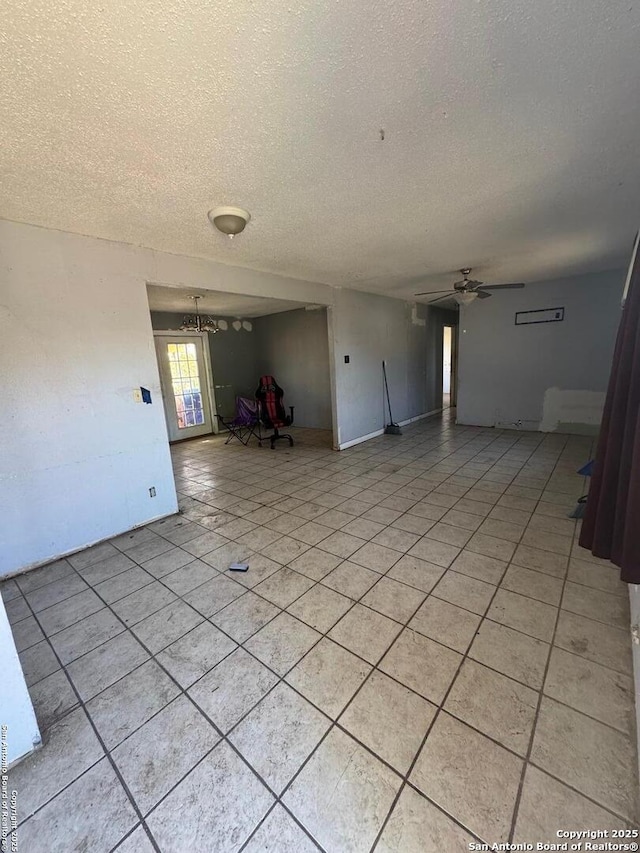 unfurnished room featuring ceiling fan, light tile patterned floors, and a textured ceiling