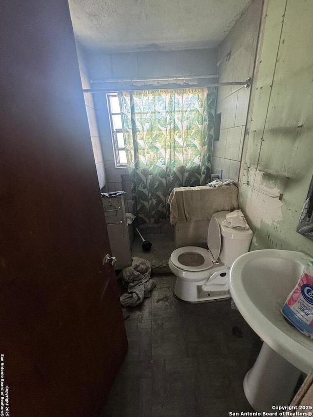 bathroom featuring sink, a textured ceiling, and toilet