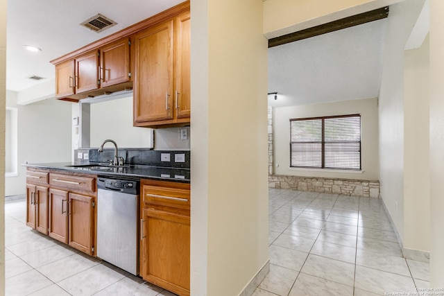 kitchen featuring sink, dark stone countertops, light tile patterned floors, dishwasher, and decorative backsplash