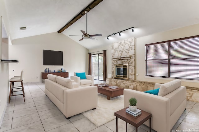 tiled living room with a stone fireplace, vaulted ceiling with beams, and ceiling fan