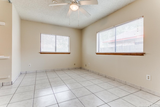 empty room featuring light tile patterned floors, a textured ceiling, and ceiling fan