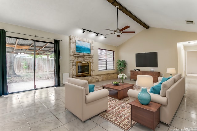 living room with ceiling fan, vaulted ceiling with beams, light tile patterned flooring, and a fireplace