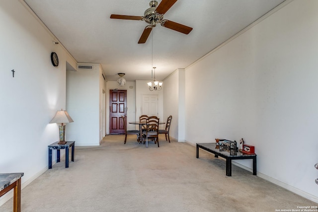 dining space with ceiling fan with notable chandelier and light colored carpet