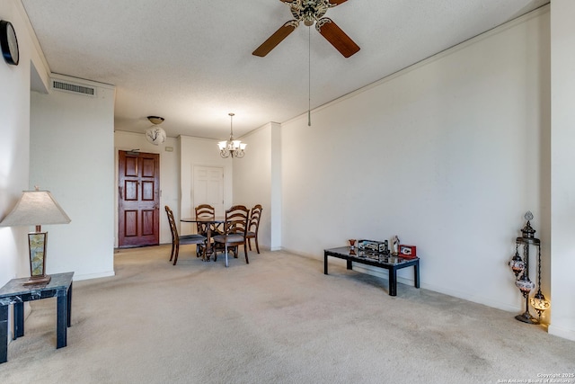 carpeted dining room with ceiling fan with notable chandelier and a textured ceiling