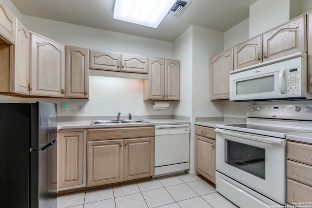 kitchen featuring light tile patterned flooring, sink, light brown cabinets, and white appliances