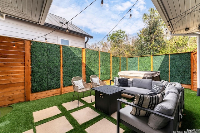 view of patio / terrace featuring a hot tub and an outdoor living space with a fire pit