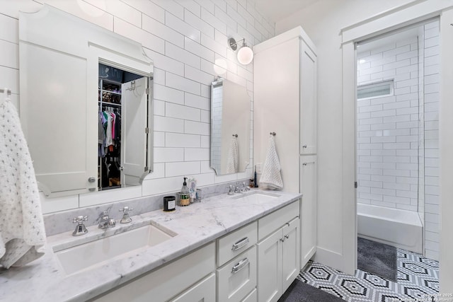 bathroom with vanity, tiled shower / bath, tile patterned floors, and tile walls