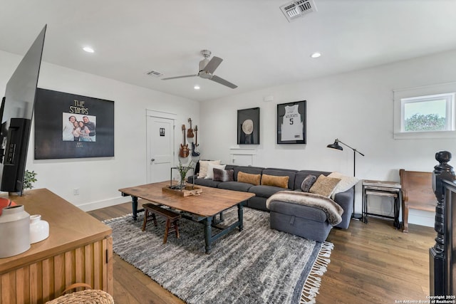 living room featuring dark wood-type flooring and ceiling fan