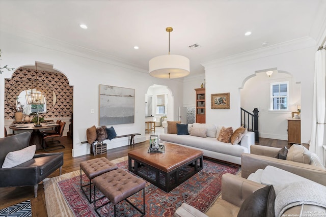 living room with crown molding, a healthy amount of sunlight, and dark hardwood / wood-style flooring