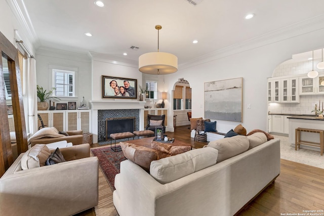 living room with hardwood / wood-style floors, a fireplace, and ornamental molding