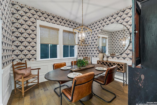 dining area with wood-type flooring and a chandelier