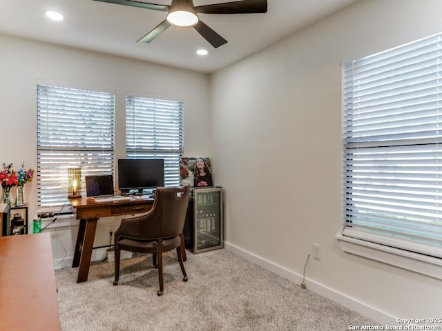 office space with a wealth of natural light, light carpet, and ceiling fan