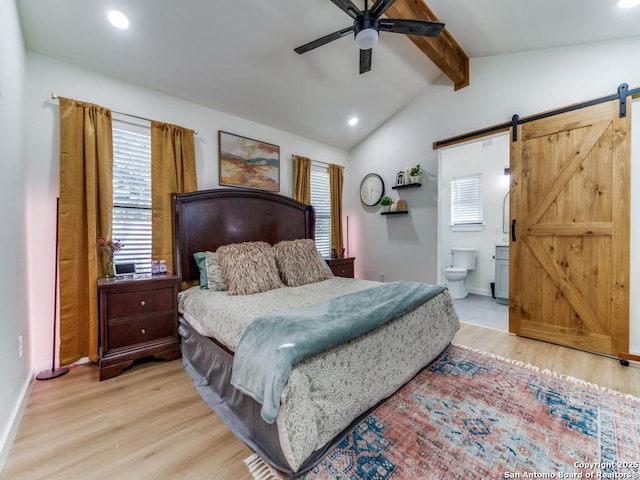 bedroom with vaulted ceiling with beams, ensuite bath, light hardwood / wood-style flooring, and a barn door