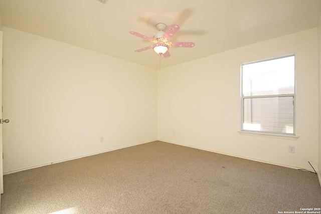 carpeted spare room featuring ceiling fan