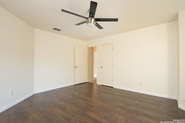 spare room featuring dark wood-type flooring and ceiling fan