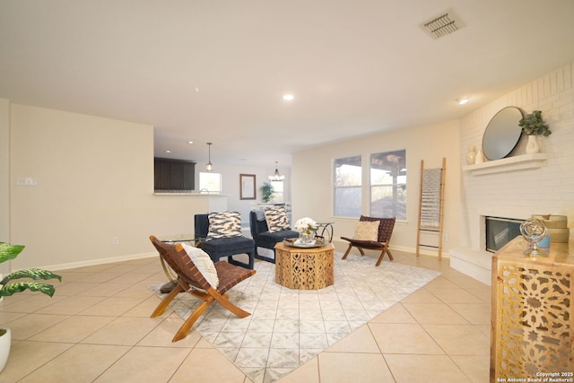 tiled living room featuring a fireplace and a notable chandelier