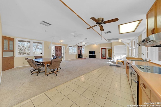 carpeted dining area featuring sink and ceiling fan