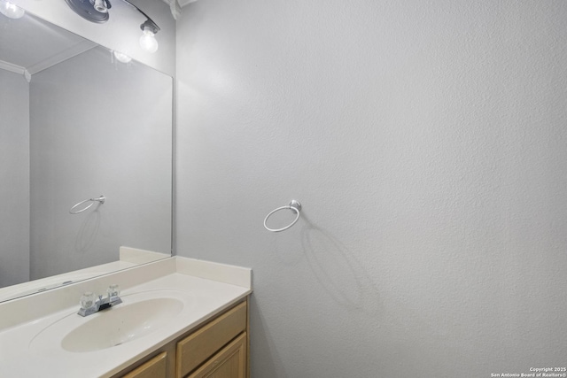 bathroom with crown molding and vanity