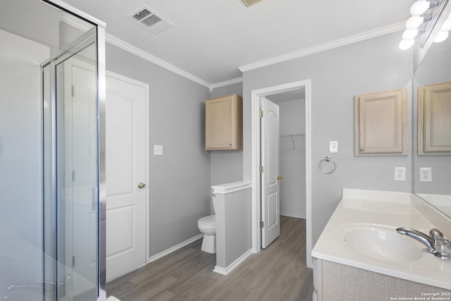 bathroom with vanity, a shower with shower door, ornamental molding, and wood-type flooring