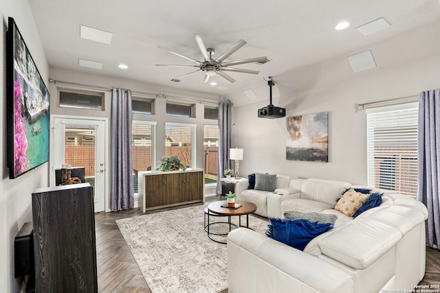 living room with ceiling fan, dark parquet flooring, and a wealth of natural light