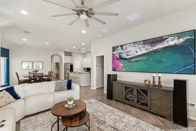 living room with sink, dark parquet floors, and ceiling fan