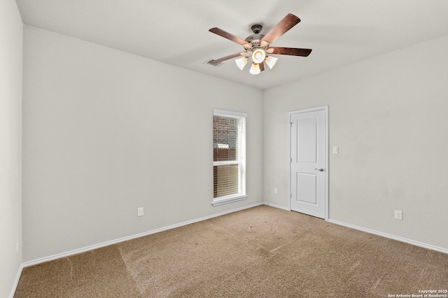 empty room featuring ceiling fan and carpet