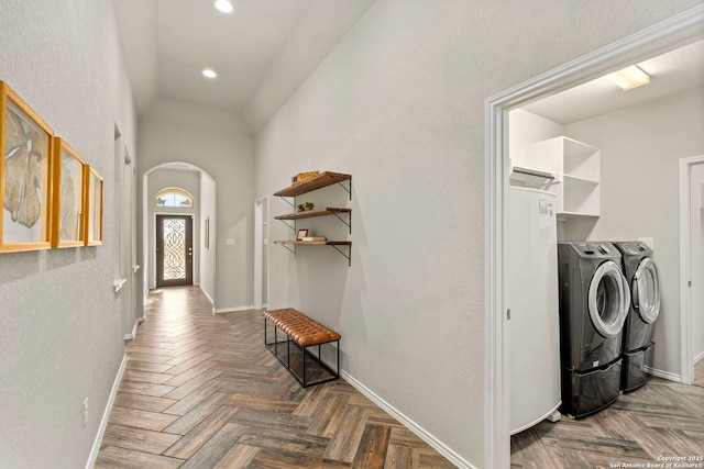 hall with parquet floors, vaulted ceiling, and washing machine and dryer