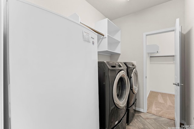 clothes washing area with independent washer and dryer and light parquet floors