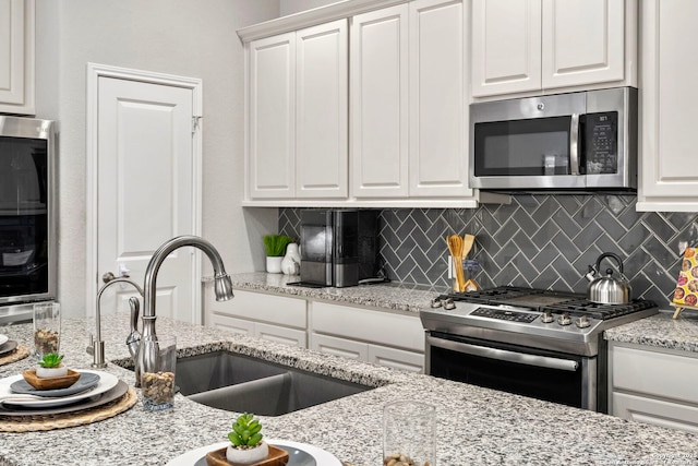 kitchen with white cabinetry, sink, tasteful backsplash, and appliances with stainless steel finishes