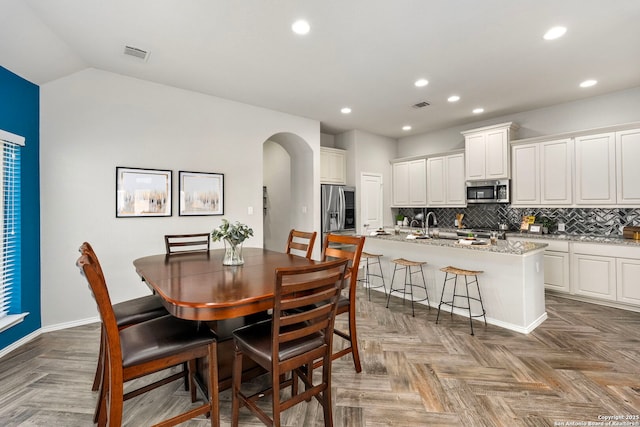 dining space featuring lofted ceiling and parquet floors