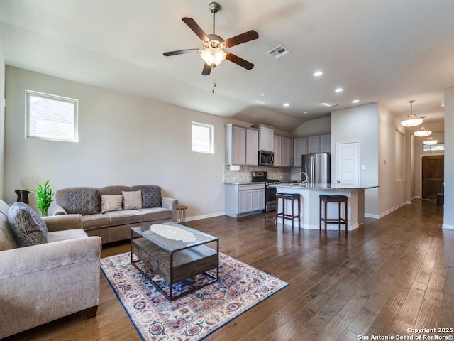 living room with ceiling fan, lofted ceiling, sink, and dark hardwood / wood-style flooring