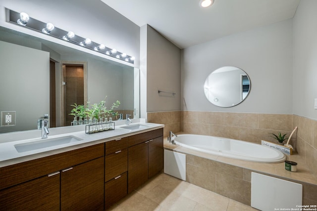 bathroom with tile patterned floors, vanity, and tiled tub