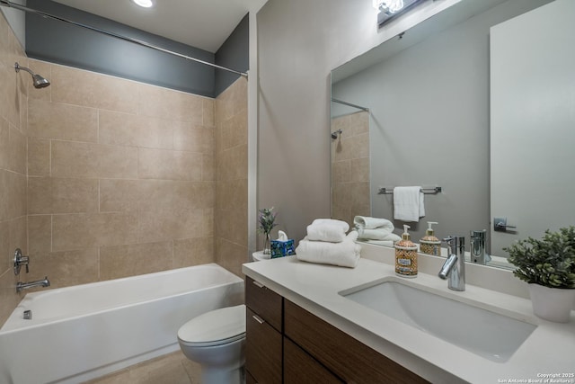 full bathroom featuring tiled shower / bath combo, vanity, tile patterned flooring, and toilet