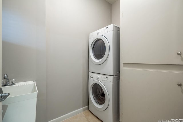 laundry area with light tile patterned flooring and stacked washer and clothes dryer