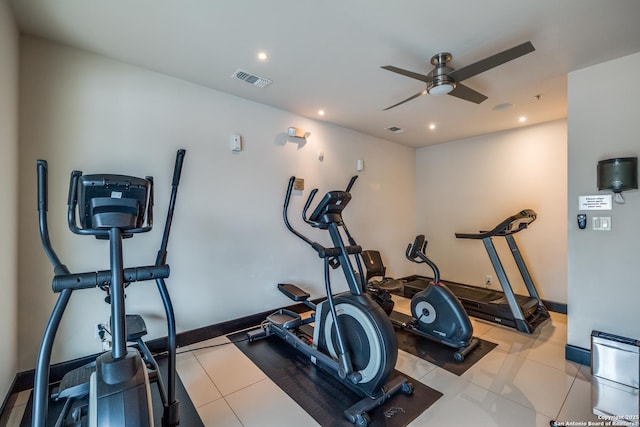 exercise area with light tile patterned floors and ceiling fan