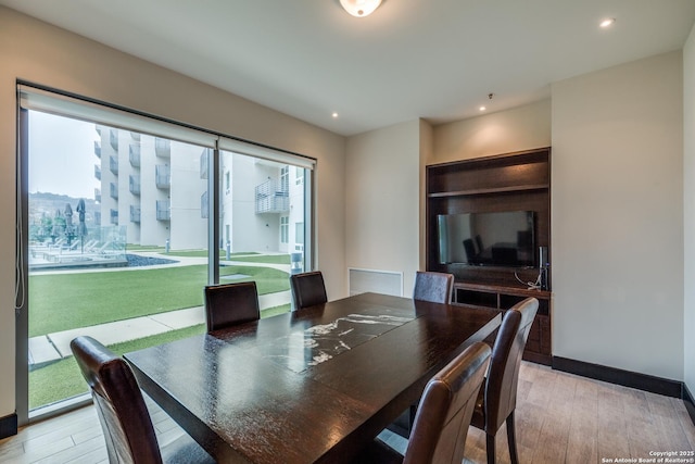 dining room with golf simulator and light hardwood / wood-style flooring